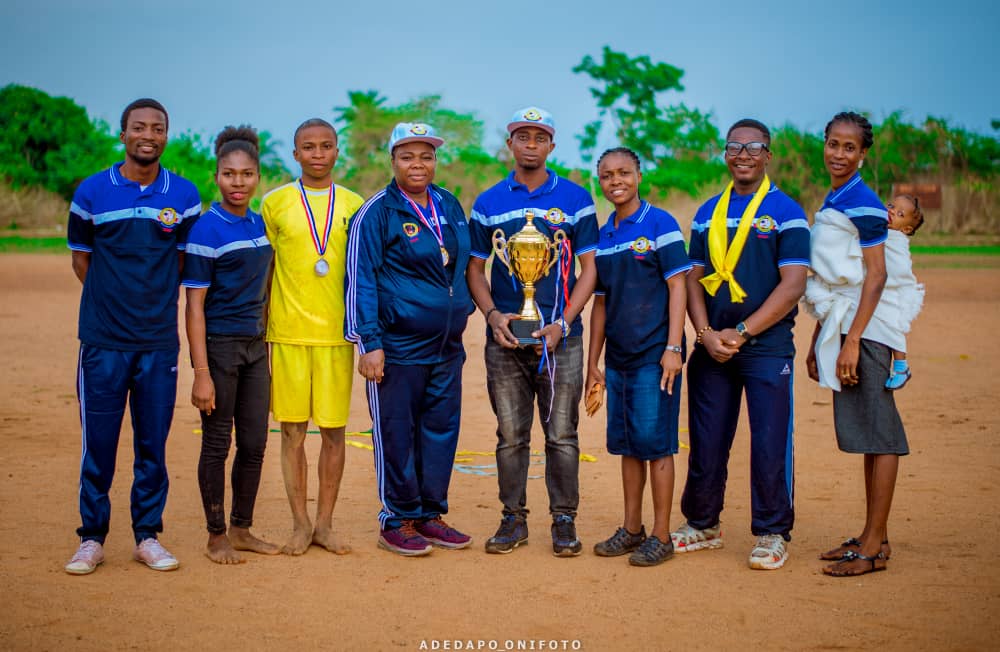 Sports team officials with trophies and medals