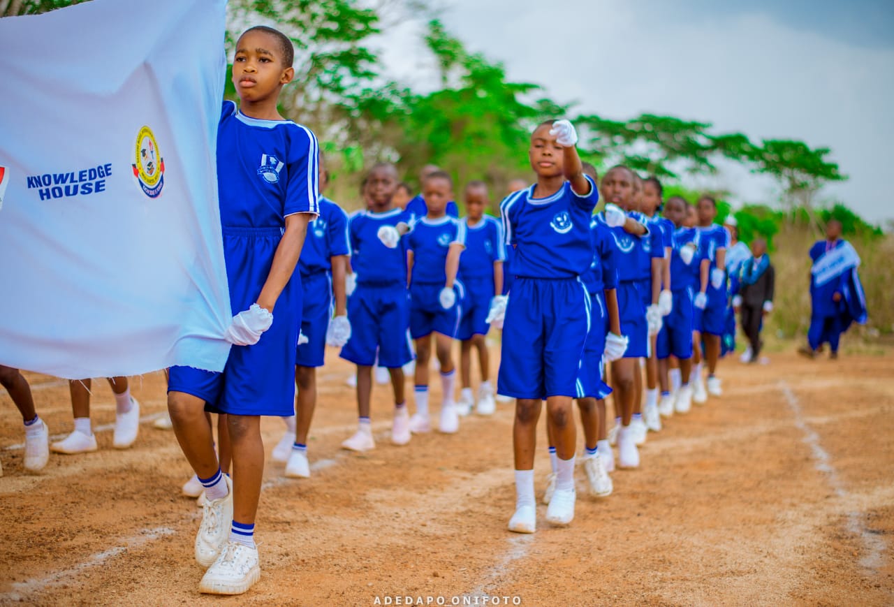 Knowledge house students marching in blue uniforms