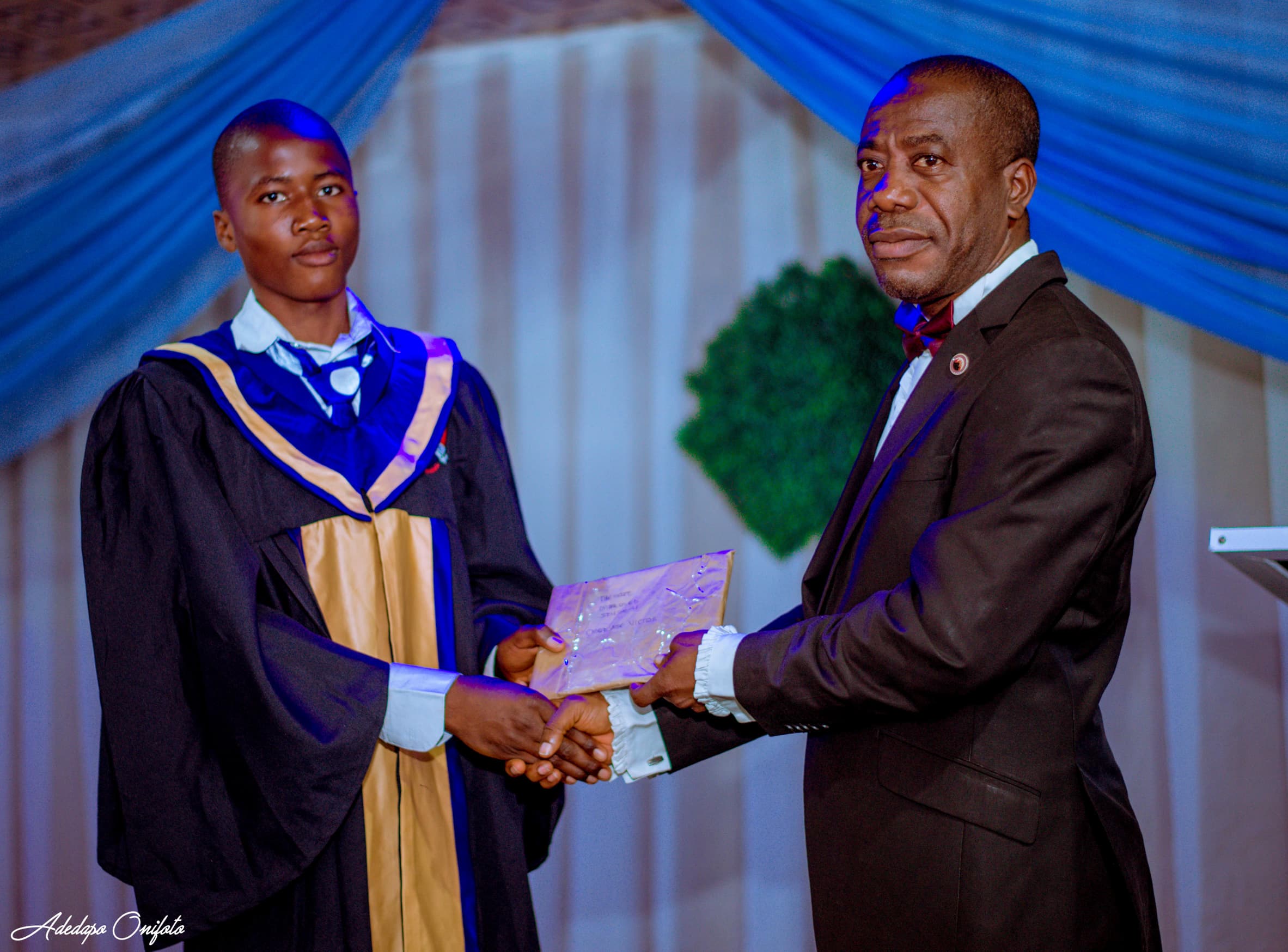 Graduate receiving certificate from school leader