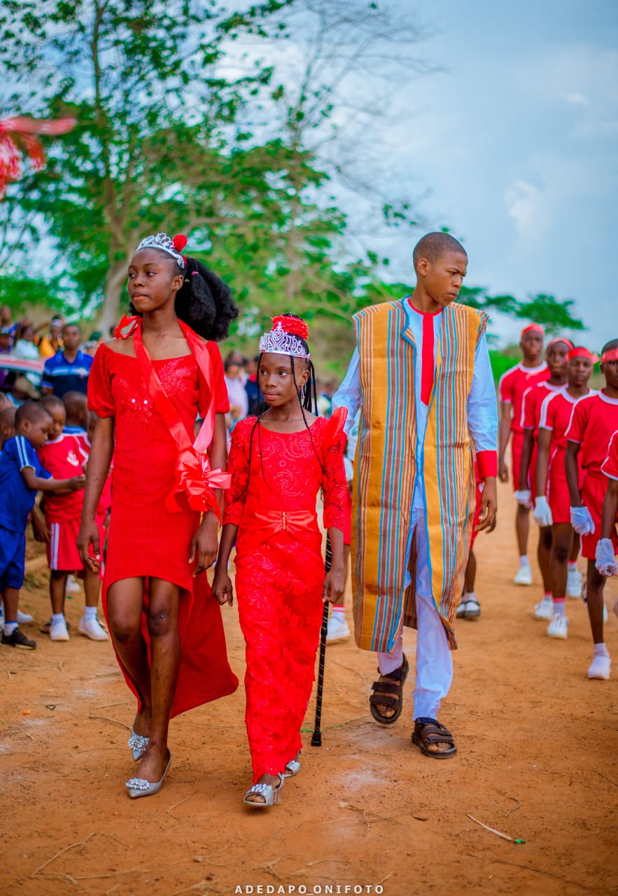 Students in red attire leading ceremonial procession